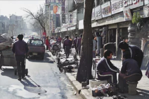 가로수의 상태로 보아 겨울로 추정되며, 구두닦이로 보이는 사람들이 모여 앉아 이야기를 나누며 불을 쬐고 있다. 뒤에는 갈아 끼울 연탄에 연탄집게가 꽂혀 대기하고 있다. 11