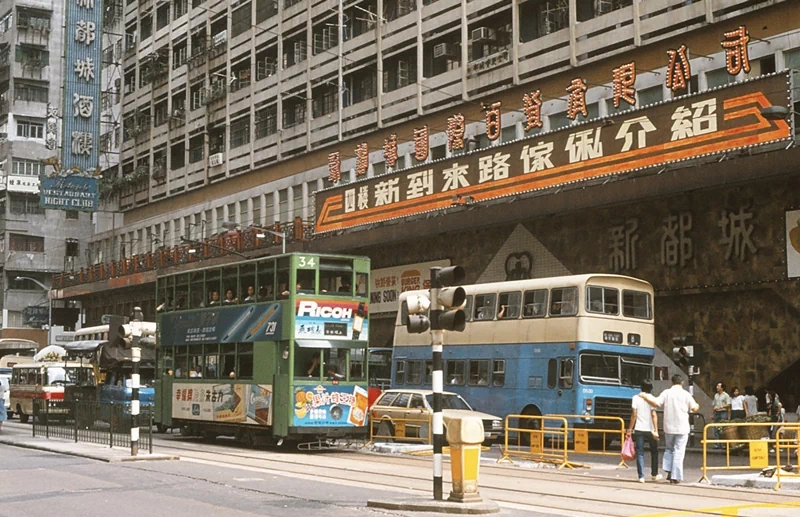 ▲ 1970년대 중반, 홍콩의 항공 뷰. 빅토리아항(Victoria Harbour)을 중심으로 아직 마천루가 드물게 보이는 도시 확장 초기의 모습이다. ▲ 1970~1980년대, 빅토리아항 페리(Victoria Harbour Ferry)에서 바라본 홍콩의 모습. 15층 내외의 빌딩들이 현재의 초고층 스카이라인과 대비되는 모습이다. ▲ 1970년대, 구불구불한 산악도로를 달리는 차량. 1970년대 홍콩의 지형적 특성을 보여주고 있다. ▲ 1970년대, 홍콩 샤틴 플로팅 레스토랑(Sha Tin Floating Restaurant). 싱문 강 위에 정박해서 화려하게 불을 밝히던 이곳은 오랫동안 샤틴의 랜드마크였으나 재개발로 인해 강제로 현재 위치로 이전하였으며 2018년 부터 '클럽원 리베이라(ClubONE Riviera)'라는 상호로 변경하였다. ▲ 1980년대, 헤네시 로드(Hennessy Road, 軒尼詩道). 영국 총독 존 포프 헤네시(John Pope-Hennessy)의 이름을 딴 1.86km 길이의 이 도로는 2014년 시위현장이자 영화 '크로싱 헤네시(Crossing Hennessy, 2009)'의 배경이기도 하다. ▲ 1980년대, 네온사인으로 물든 홍콩의 밤거리. 할리우드 로드(Hollywood Road) 인근에서 촬영된 이 네온 간판들은 상업도시로 눈부시게 발전하던 홍콩의 활력을 상징한다. ▲ 1973년, 포팅거 스트리트(Pottinger Street, 砵典乍街)에서 짐을 나르는 인부. 300m 화강암 계단으로 1858년 홍콩의 초대 총독인 헨리 포팅거(Henry Pottinger)의 이름을 따서 명명된 이곳은 현재는 관광명소로 변모하였다. ▲ 1988년, 침사추이(Tsim Sha Tsui, 尖沙咀)의 비내리는 풍경. 중앙에 익숙한 한글로 '삼오정'이라는 한식당 간판이 보인다. ▲ 1986년, 웨스턴 스트리트(Western Street)의 전통 인력거. 교통수단이 아니라 관광용으로 이 시기 홍콩은 이미 세계적인 관광지였다. ▲ 1970~1980년대, 신문과 잡지 가판대 옆에서 부모를 대신해 자리를 지키는 것으로 보이는 아이가 식사를 하고 있다. ▲ 1970년대, 아파트 발코니의 풍경. 고밀도 주거문화가 시작되던 주택가의 풍경을 보여주고 있다. ▲ 홍콩 카이탁 공항(Kai Tak Airport, 啟德機場)의 활주로. 이 공항은 1998년에 폐쇄되었으며, 위험한 착륙과정 때문에 '세계 10대 위험공항'에 단골로 선정되었다. ▲ 침사추이 인근의 전자제품 매장. 간판 중에 '한강백화점'이 보인다. ▲ 어지러운 간판과 노점상으로 가득한 골목. 1980년대 홍콩의 카오스 미학을 보여주는 장면이다. ▲ 퀸즈 로드 센트럴(Queen's Road Central)을 지나가는 2층 트램. 영국인들에 의해 건설된 홍콩 최초의 도로인 '퀸즈 로드(Queen's Road)' 구간 중 하나로 중국어 명칭 '황후대도(皇后大道)'에는 여왕(Queen)을 황후(皇后)로 오역한 역사적 실수가 담겨 있다. ▲ 1970~1980년대, 노점이 늘어선 홍콩의 거리. ▲ 1970~1980년대, 광고로 랩핑된 2층 버스. 영국 식민지 시대의 유산으로 지금도 운행 중이다. ▲ 1970~1980년대, 노천에서 고기를 처리하는 정육점. 현대적 위생시설 도입 전의 전통적 유통 방식을 보여주고 있다. ▲ 1980년, 노스 포인트 트램(North Point Tram)과 2층 버스가 교차하고 있다. ▲ 1982년, 홍콩 상하이 스트리트(Shanghai Street)의 전통 찻집. ▲ 1978년, 생선 장수와 가정주부들로 북적이는 타이위엔 스트리트(Tai Yuen Street). 북적이는 인파와 화려한 간판, 고밀도의 주택과 화분이 놓여 있는 발코니가 어우러진 모습은 이 시기 홍콩의 풍경을 압축해서 보여주고 있다. 37
